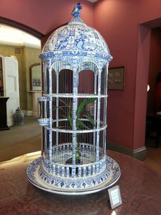 a blue and white birdcage sitting on top of a table in a room