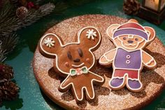 two decorated cookies sitting on top of a wooden plate