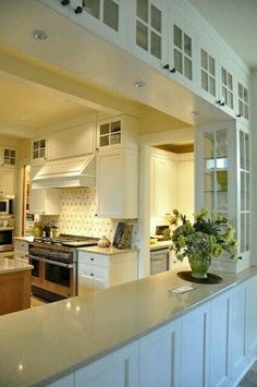 an open kitchen with white cabinets and counter tops