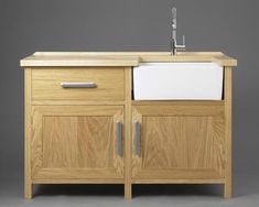 a wooden sink cabinet with a white counter top and chrome faucet on the side