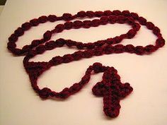 a crocheted red cross on a white surface