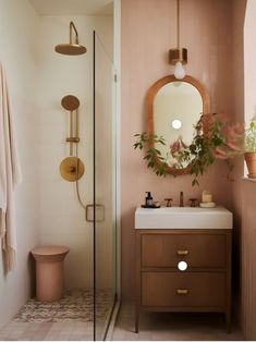 a bathroom with a sink, mirror and shower in it's corner next to a toilet