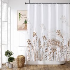 a bathroom with a shower curtain and potted plant on the floor next to it