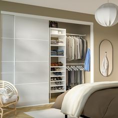 a bedroom with a bed, chair and closet