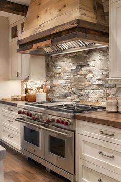 a stove top oven sitting inside of a kitchen next to white cabinets and wooden counter tops