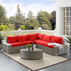 an outdoor living room with red cushions and furniture