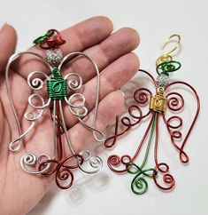 two handmade christmas ornaments in the palm of someone's hand