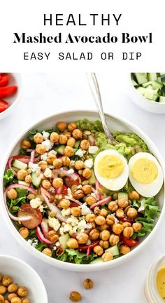 a salad with hard boiled eggs, lettuce and red onions in it on a white table