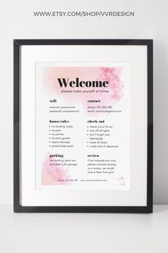 a framed poster with the words welcome and pink watercolor flowers on it, in black frame