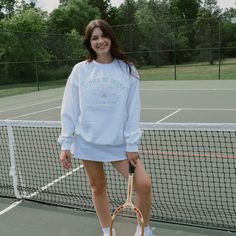 Serve up some style with this cute and classy tennis club crew. This classic style is perfect for a day on the court or just sipping some lemonade at your local country club. Pair with a cute tennis skirt or our simple belt bag for the perfect preppy outfit. This white crew will have your sorority name embroidered in green thread about two cute tennis rackets and your sorority's established date on either side. Model is wearing a size large White crew with bright pink and green embroidery Country Club Preppy Outfit, Trendy White Tennis Skirt For School, White Preppy Tennis Skirt For School, Preppy Tennis Dress For Spring, White Preppy Tennis Dress For Spring, Preppy Spring Tennis Dress, Spring Preppy Tennis Dress, Casual White Tennis Dress, Casual Tennis Skirt For Pickleball In Spring