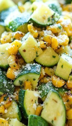 a white bowl filled with cucumber and corn salad on top of a table