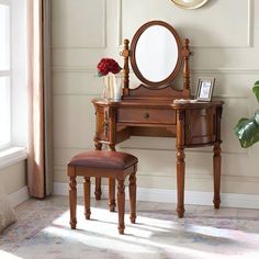 a dressing table with a mirror, stool and plant in front of it on the floor