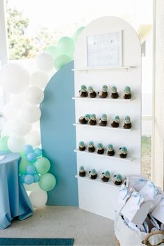 a baby's first birthday party with balloons and cupcakes on the wall