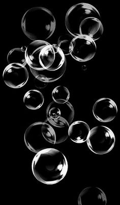 many bubbles floating in the air on a black background