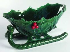 a green glass bowl with holly and berries on it