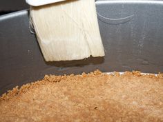 a close up of a pan with food in it and a brush sticking out of the top