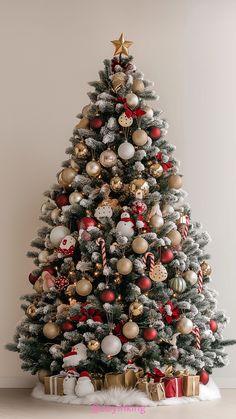 a christmas tree decorated with ornaments and gold, white and red balls is shown in this image