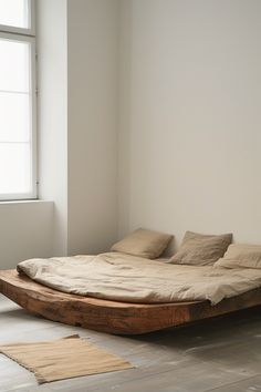 a bed sitting on top of a wooden floor next to a window