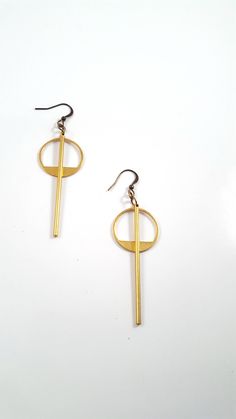 Simple and understated, these modern minimalist earrings are a great go to for everyday wear, to work or a night out. The earrings feature a long golden brass bar that is chin grazing through the middle of a brass geometric circle. These lightweight earrings hang about 2.75 inches in length while the circle hangs 1.5 inches length. The entire look is topped off with a nickel and lead free french ear wire. For more earrings check out our selection here: https://www.etsy.com/shop/DyNaModuo?section Simple Design Modern Gold Earrings, Modern Simple Design Gold Earrings, Modern Matte Gold Earrings, Matte Gold Minimalist Earrings, Modern Gold Earrings With Simple Design, Matte Gold Minimalist Metal Earrings, Minimalist Circle Brass Earrings, Geometric Metal Earrings For Everyday, Minimalist Metal Plug Earrings For Everyday