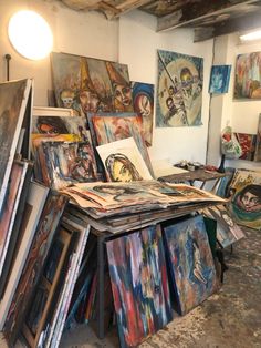 an artist's studio with many paintings on display