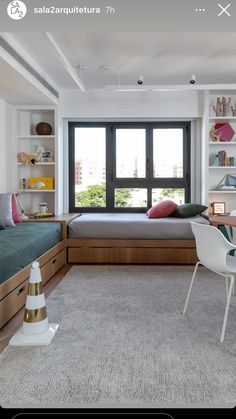 a bedroom with a bed, desk and chair next to a window in the room