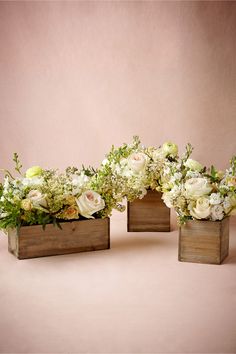 three wooden vases filled with white flowers