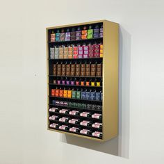 a wall mounted display case filled with lots of different colored drinks and condiments