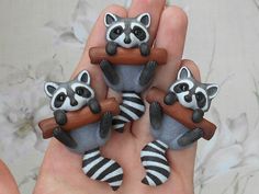 three raccoon figurines are sitting in the palm of someone's hand