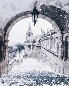 an archway leading to a building with snow on the ground