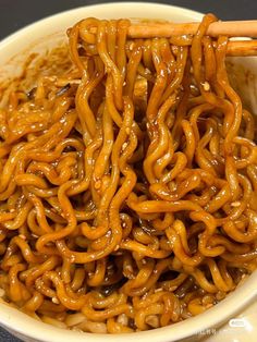 a bowl filled with noodles and chopsticks