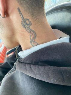 the back of a man's head with a tattoo on his neck and ear