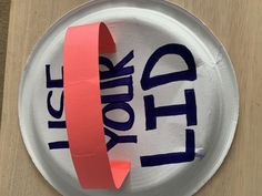 a paper plate with the word help written on it and a red tape attached to it