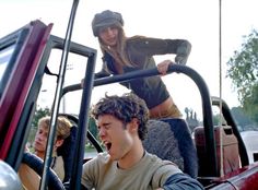 a group of young men riding on the back of a truck