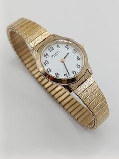 This Vintage Gold Tone Rotatory Bravely Watch is a timeless classic. The gold bracelet creates a versatile and elegant design, while the precise Rotatory movement ensures accurate timekeeping. With a vintage charm and modern reliability, this watch is the perfect accessory for any occasion. In working order. Has minor wear on, please see pictures.  Length: 19cm Dial width: 2.4cm Pricing depends on uniqueness of the watch, brand name, condition, price paid for the pieces and cost of materials. Si Classic Gold Analog Watch Accessories, Classic Gold Watch With Jubilee Bracelet, Classic Watches With Jubilee Bracelet And Round Dial, Classic Watches With Jubilee Bracelet, Wrist Watches, Timeless Classic, Vintage Charms, Vintage Gold, Brand Names