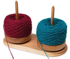 two spools of yarn sitting on top of a wooden stand