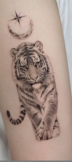 a tiger sitting on the ground next to a crescent moon and star tattoo designs for women