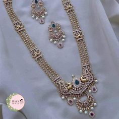 Embrace the timeless elegance of South Indian tradition with this stunning gold-plated haram necklace and earrings set. This exquisite piece features an intricate design adorned with sparkling CZ stones and delicate pearls, reminiscent of the grandeur of ancient temples. The long, layered necklace cascades down your chest, drawing attention to your neckline with its captivating beauty. Crafted with meticulous attention to detail, this set is perfect for: Bridal wear: Add an air of timeless sophistication to your wedding look with this breathtakingly beautiful set. Party wear: Make a statement at any special occasion with this eye-catching piece that is sure to turn heads. Cultural events: Immerse yourself in the rich heritage of South India with this authentic and elegant jewelry set. Feat Long Beads Haram, Stone Long Haram Gold, Pearl Haram Designs Gold, Rani Haram Designs Gold, Rani Har Gold, Rani Haram, Chest Drawing, Rani Har, Temple Jewellery Set