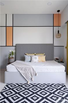 a modern bedroom with an upholstered bed and black and white rug on the floor