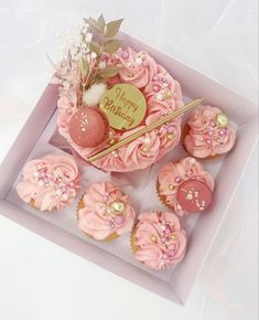 pink cupcakes in a box with gold decorations