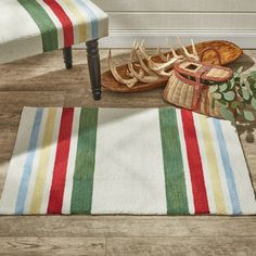 a pair of sandals sitting on top of a wooden floor next to a striped rug