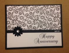 a happy anniversary card with a black flower on the front and white background, decorated with an embellishment