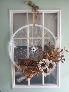 a window with a sign that says hello on it and flowers in front of it