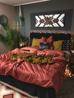 a bed with red sheets and pillows in a bedroom decorated for christmas or new year's eve