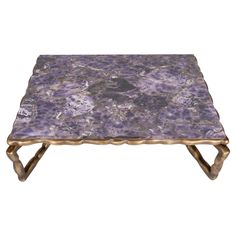 a purple marble topped coffee table with gold legs and an intricate design on the top