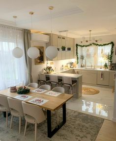 a dining room table and chairs in front of a kitchen