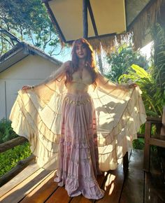 a woman in a long dress standing on a deck