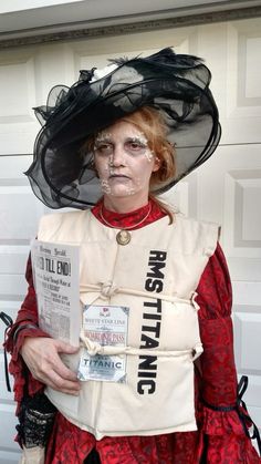 a woman dressed in costume and makeup holding a piece of paper with writing on it