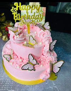 a pink birthday cake with butterflies on it