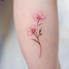 a small pink flower tattoo on the leg