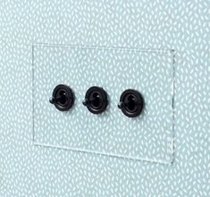 two black buttons on a light switch cover